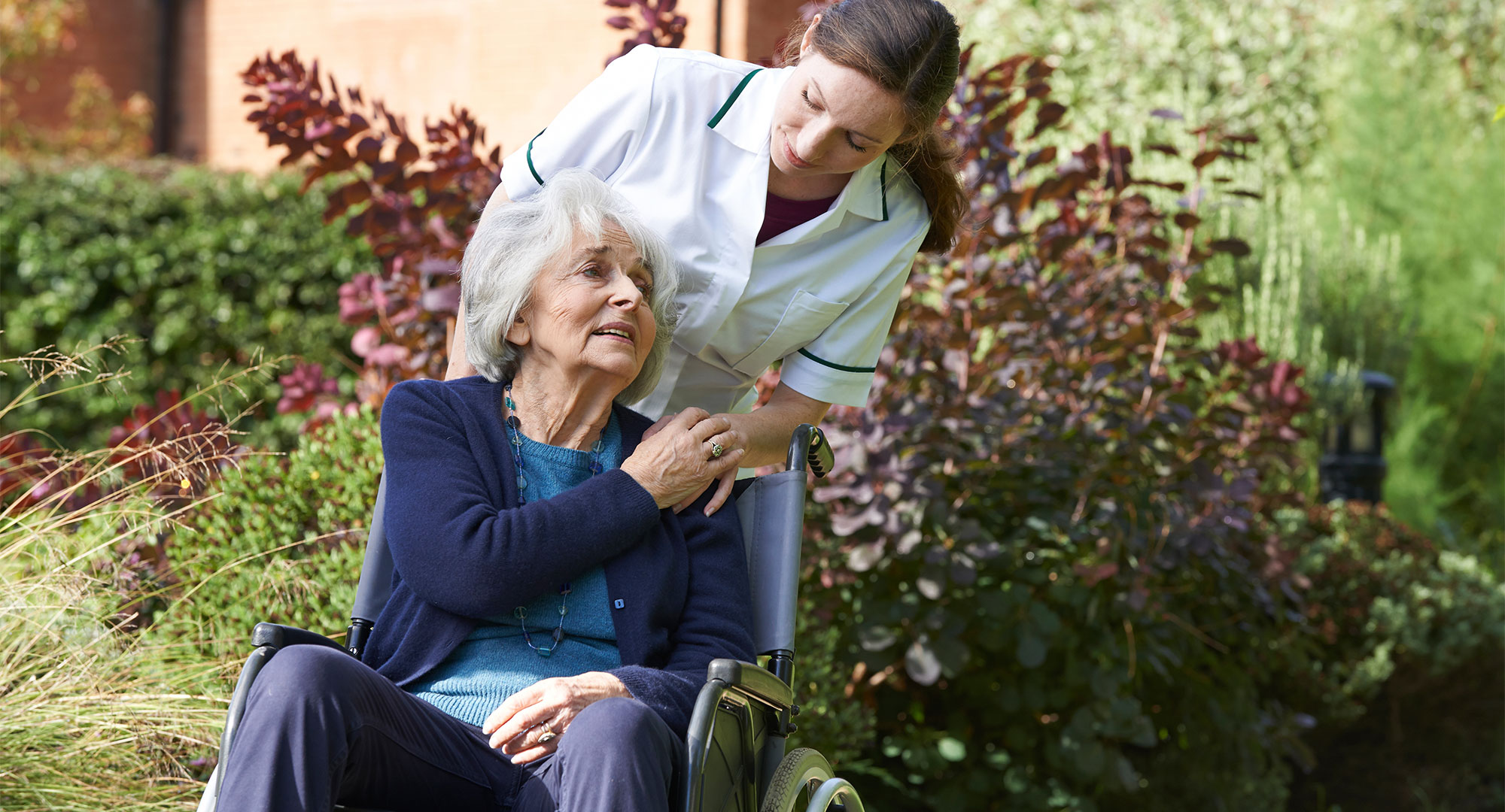 Seniorin im Rollstuhl mit Pflegerin