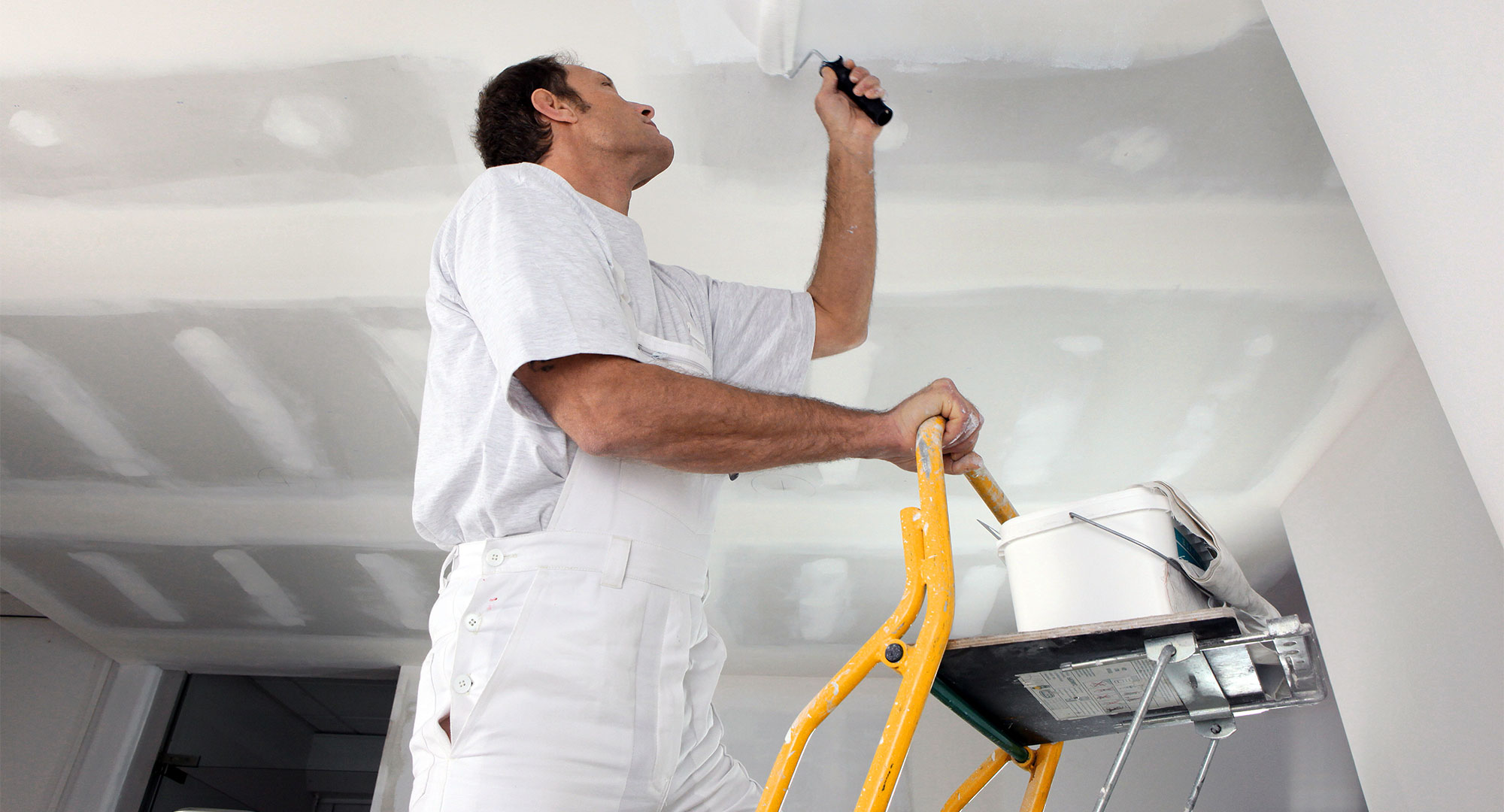 Maler und Lackierer streicht eine Decke